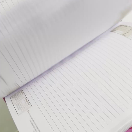 Person flipping through the blank pages of a5 page-a-day diary with hot pink cover design