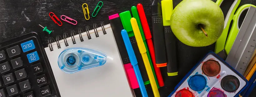 A colorful flat lay of school stationery and office essentials, including a calculator, notebook, markers, and art supplies available at The Inky Shop.